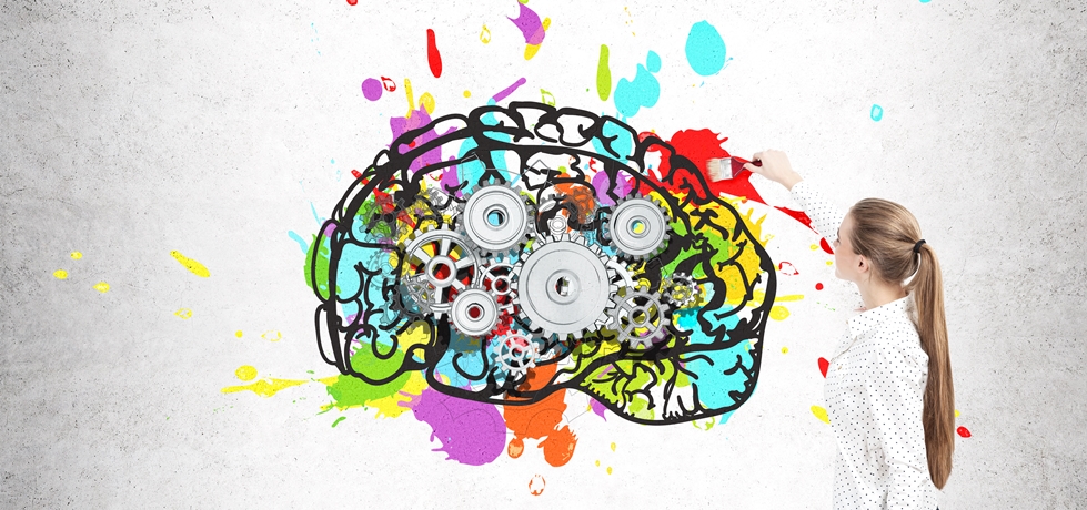 mulher pintando um esboço de cérebro colorido em uma parede