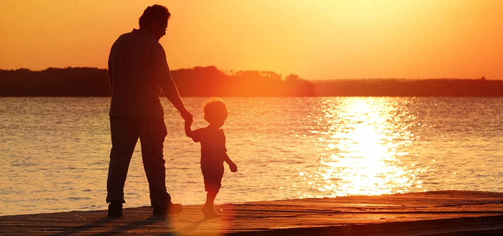Pai e filho caminhando ao pôr do sol
