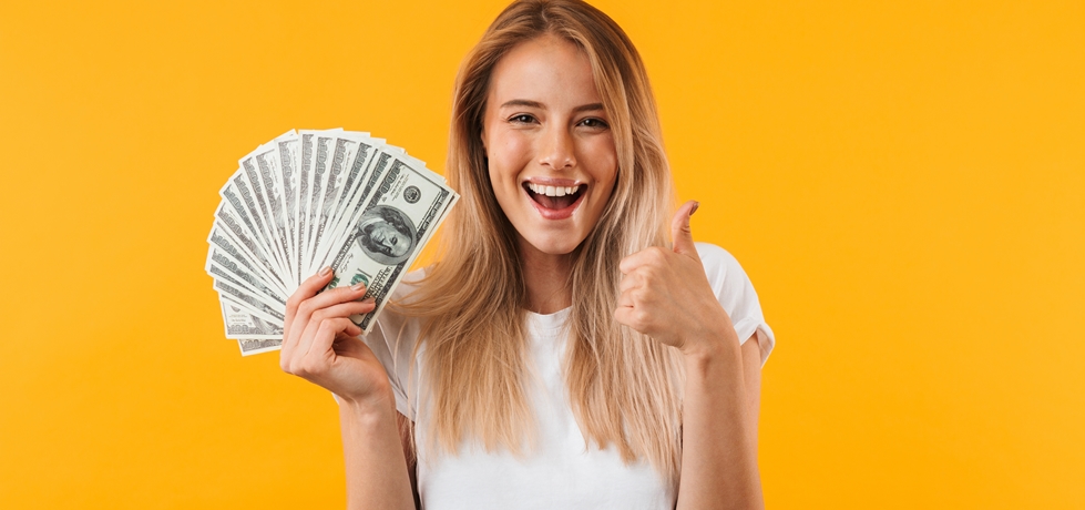 Mulher sorrindo mostrando monte de notas de dinheiro