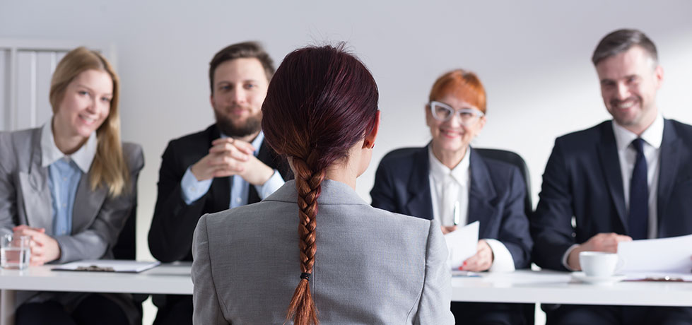 Mulher em entrevista de emprego respondendo assertivamente qual seu objetivo na empresa