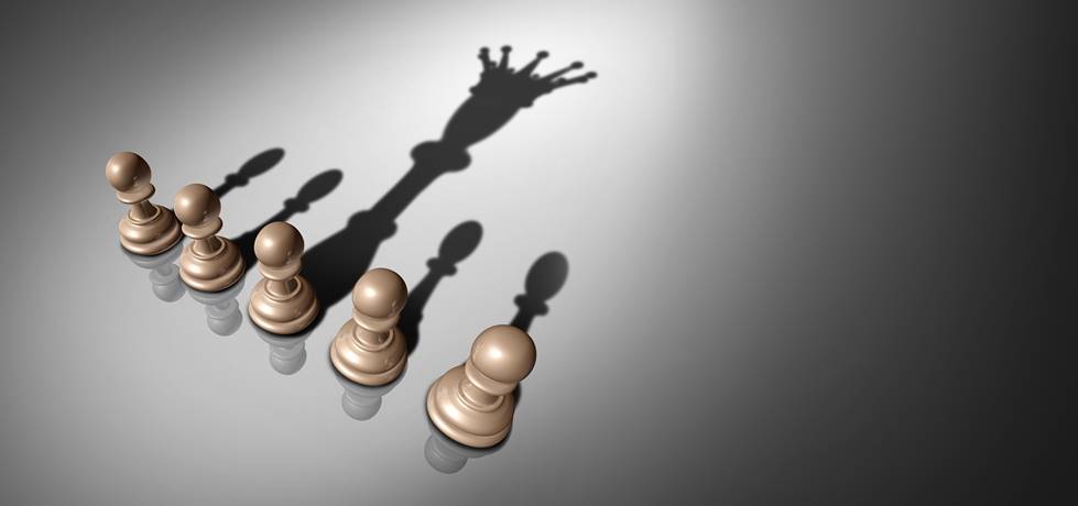 peças de peão de xadrez com uma peça lançando uma sombra de um rei