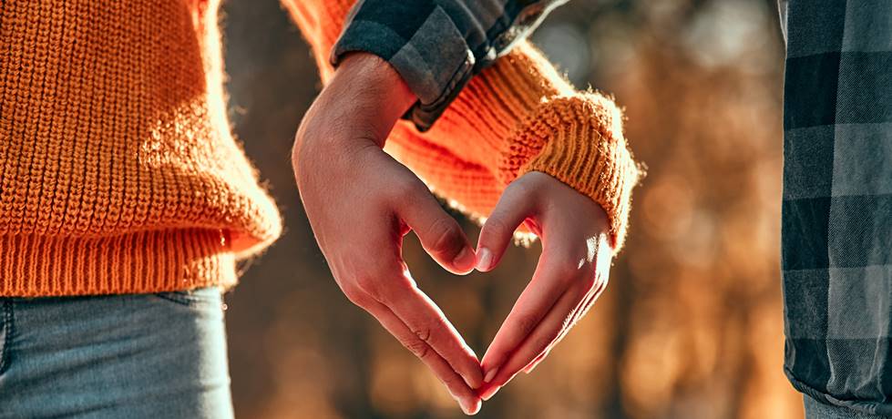 casal unindo as mãos formando um coração