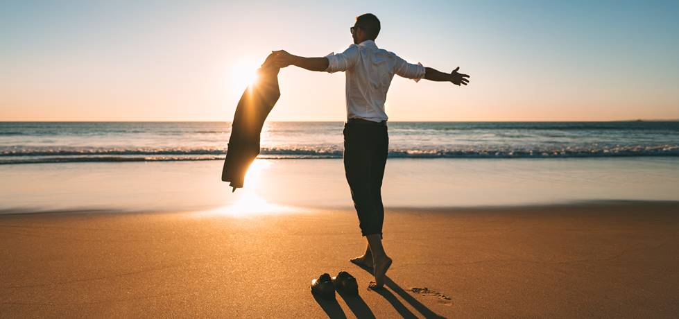 Homem de braços abertos na praia